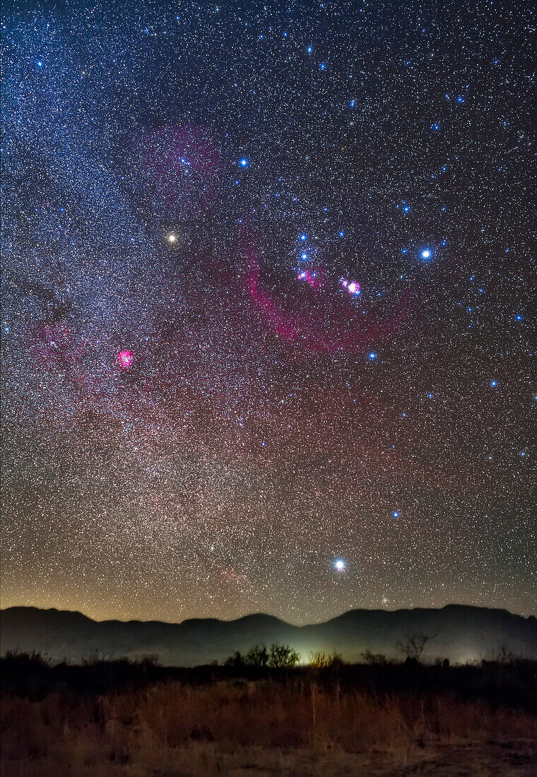 Orion und Sirius gehen in einer klaren Dezembernacht am frühen Abend über den Peloncillo Mountains im Südwesten von New Mexico auf. Die Gürtelsterne des Orion zeigen hinunter zu Sirius, dem Hundsstern.