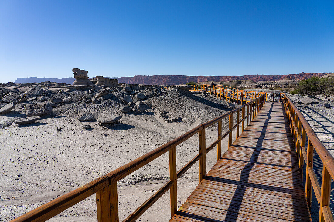 Boardwalk through eroded geologic formations in the barren landscape in Ischigualasto Provincial Park, San Juan Province, Argentina.