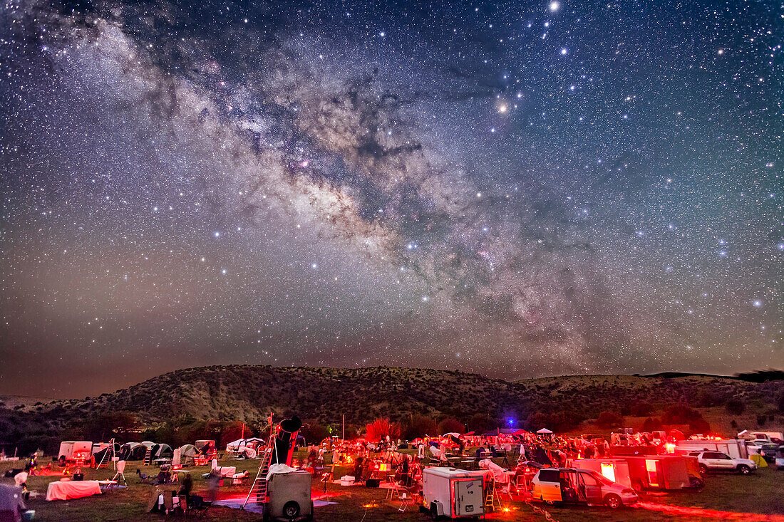 The galactic centre region of the Milky Way in Sagittarius and Scorpius, over the upper field of the Texas Star Party, near Fort Davis, Texas, May 13, 2015. About 600 people gather here each spring for a star party under very dark skies near the MacDonald Observatory. Sagittarius is left of centre and Scorpius is right of centre with the planet Saturn the bright object at the top edge right of centre. The dark lanes of the Dark Horse and Pipe Nebula areas lead from the Milky Way to the stars of Scorpius, including Antares. The semi-circular Corona Australis is just clearing the hilltop at left