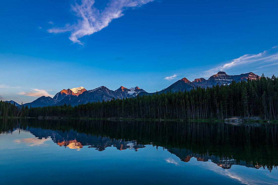 Sonnenuntergang am Herbert Lake, Banff National Park, Alberta, mit dem letzten Sonnenlicht, das die Gipfel rund um Lake Louise an der Kontinentalscheide in einem Alpenglühen erstrahlen lässt. Der Hauptgipfel links ist Mount Temple.