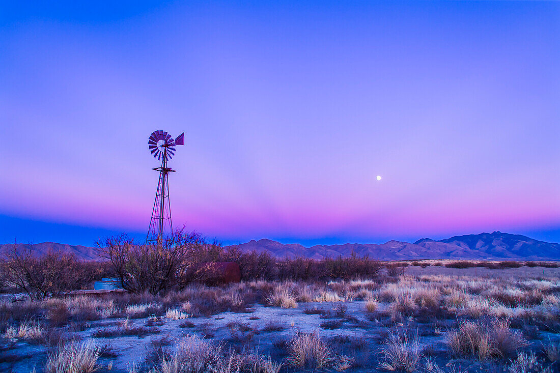 Sunset twilight colours and the waxing gibbous Moon over the Chiricahua Mountains in southeast Arizona, south of Willcox. Taken December 15, 2013 on Highway 186. Taken with the 24mm lens and Canon 5D MkII. Some dark crepuscular rays are visible converging to the anti-solar point.