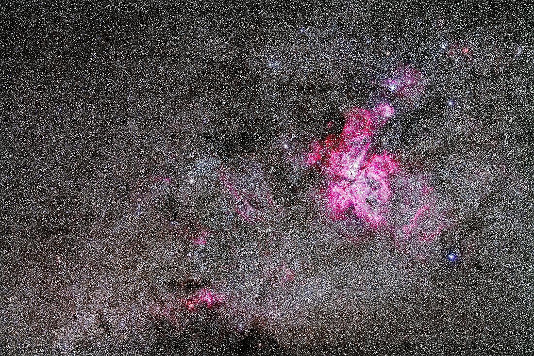 Der Carina-Nebel, NGC 3372, und der Football-Haufen, NGC 3532, links, in einer Weitwinkelaufnahme mit einem 200-mm-Teleobjektiv, um das Gesichtsfeld eines Binokulars anzupassen. Oben rechts ist der Edelsteinhaufen, NGC 3293. Unten links sind die Nebel NGC 3576 und NGC 3603 zu sehen.