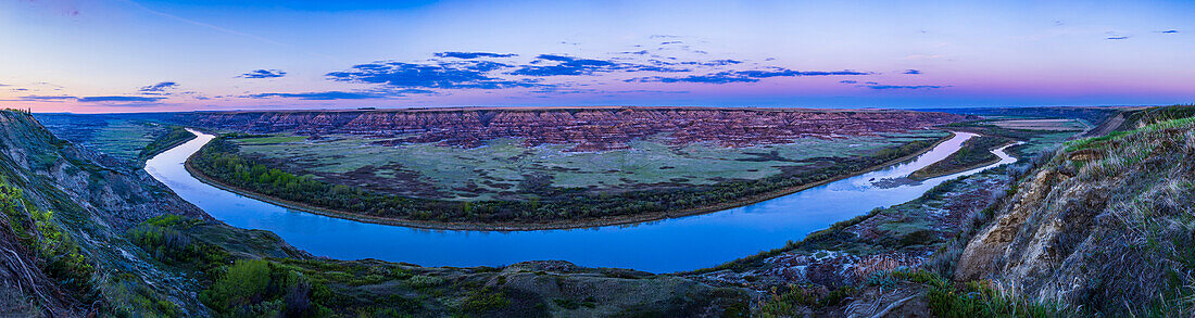 A panorama of the Badlands and evening twilight sky over the curve of the Red Deer River, Alberta, from the Orkney Viewpoint on the west side of the river, overlooking the formations of the Horsethief Canyon area to the east. This was May 21, 2022.