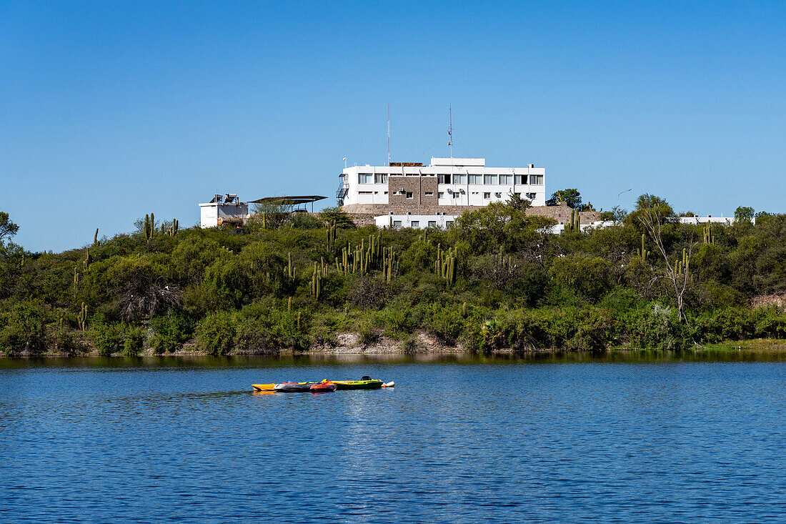 Ein Hotel an einem Stausee bei Villa San Agustin in der Provinz San Juan, Argentinien. Kajaks schwimmen auf dem See.