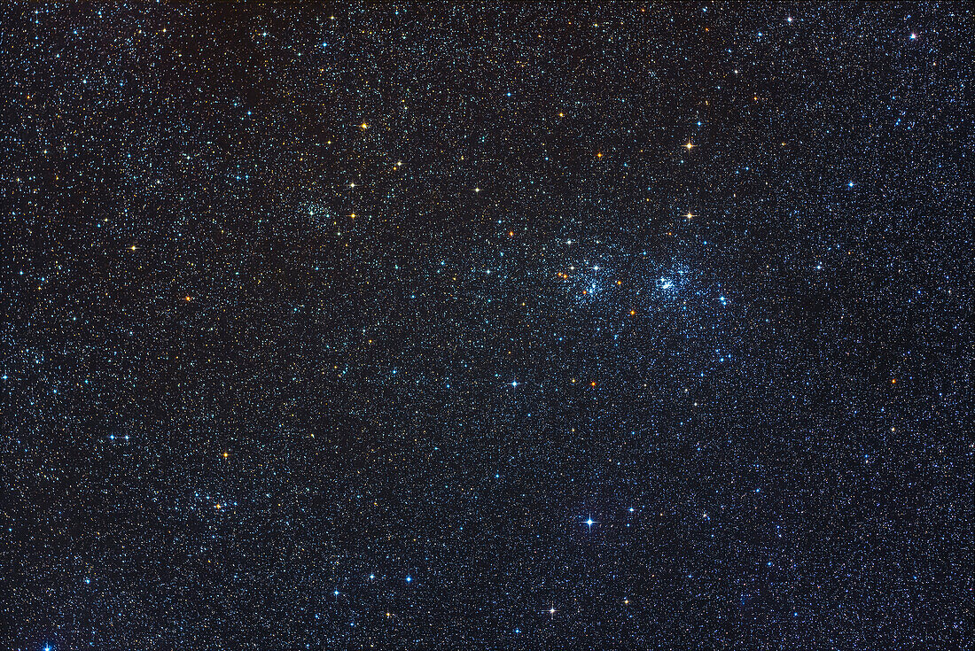 The well-known Double Cluster (aka NGC 884 and NGC 869) framed at upper right to include two of its companion star clusters, NGC 957 at upper left and Trumpler 2 at lower left. Dotted through the field of young blue stars are numerous aging yellow giant stars. And the gradation in sky colour from the clearer, bluer sky with more stars at right to the dustier, yellower sky and fewer stars at left is subtle but obvious here, from interstellar dust in this part of the Milky Way.