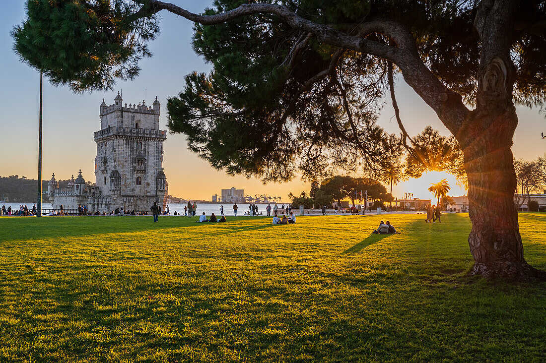 People enjoying Belen Tower Garden (Jardim da Torre de Belem) at sunset, Lisbon, Portugal