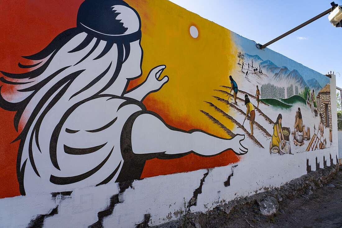 A painted wall mural depicting indigenous culture on the street in Villa San Agustin in San Juan Province, Argentina.