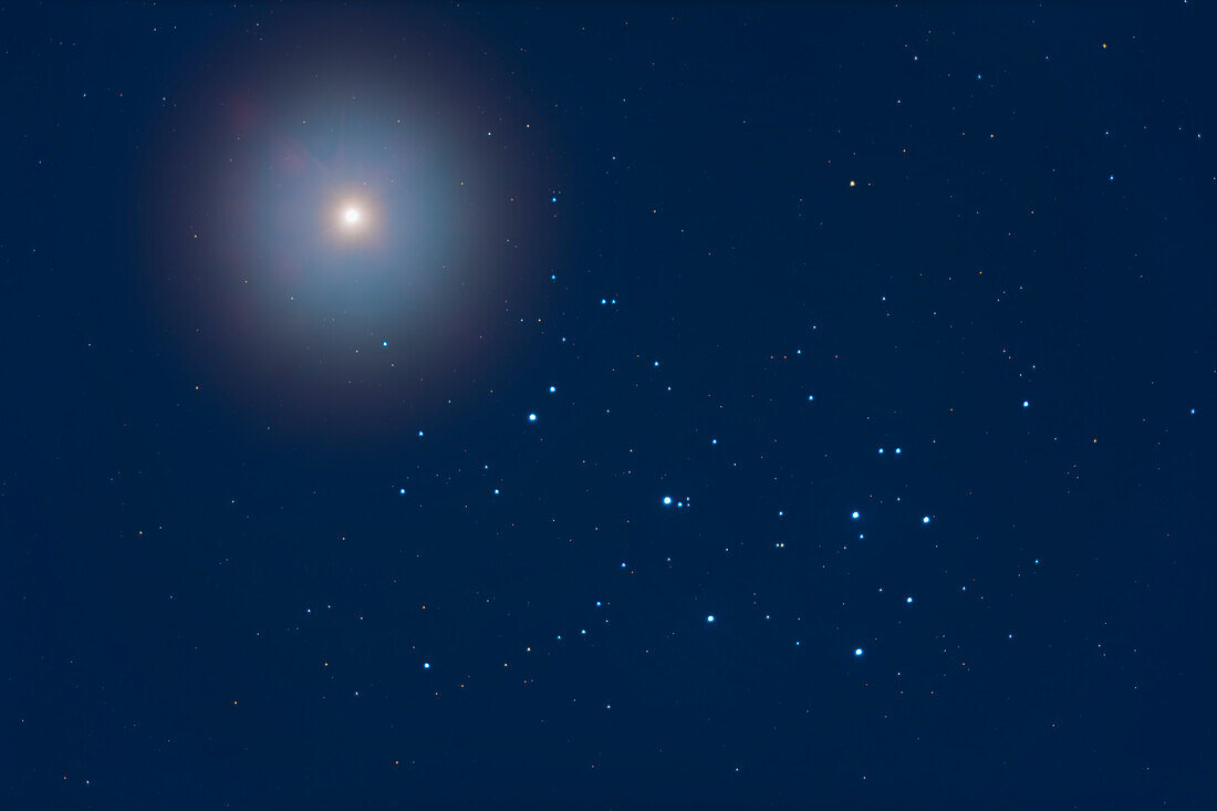 Venus über dem Sternhaufen der Plejaden, M45, am 4. April 2020, in der Dämmerung und im Mondlicht. Das Licht des Doppelmondes beleuchtete den Himmel, so dass keine Langzeitbelichtung viele Details in und um die Plejaden herum zeigen würde. Die Venus zieht nur alle 8 Jahre nahe an den Plejaden vorbei. In der Nacht zuvor war sie näher dran, aber leider waren Wolken da! Einige leichte Wolken in dieser Nacht verstärkten das Glühen.