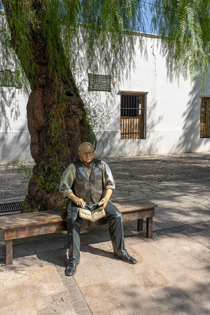 Statue of Domingo Sarmiento sitting on a bench in front of the Birthplace Museum of Domingo F. Sarmiento, San Juan, Argentina.