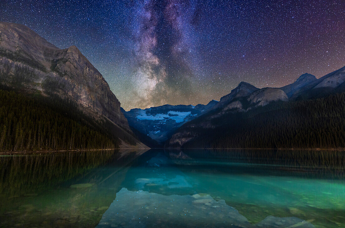 Galaxy and glacier! The Milky Way over glacier-fed Lake Louise and Victoria Glacier in Banff National Park, Alberta. The Scutum Starcloud is just above and setting over Victoria Glacier, accompanied by star clusters in Serpens and Ophiuchus. Some airglow tints the sky above the mountains green and magenta.
