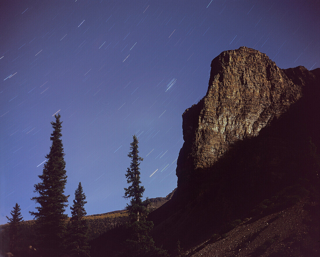 Stars of Taurus rising behind Tower of Babel peak at Moraine Lake, Banff. Taken with Plaubel Makina 6x7 camera with 80mm lens at f/5.6 and Fujichrome Velvia 50 slide film (120-format) and about 16 minute exposure in full moonlight.