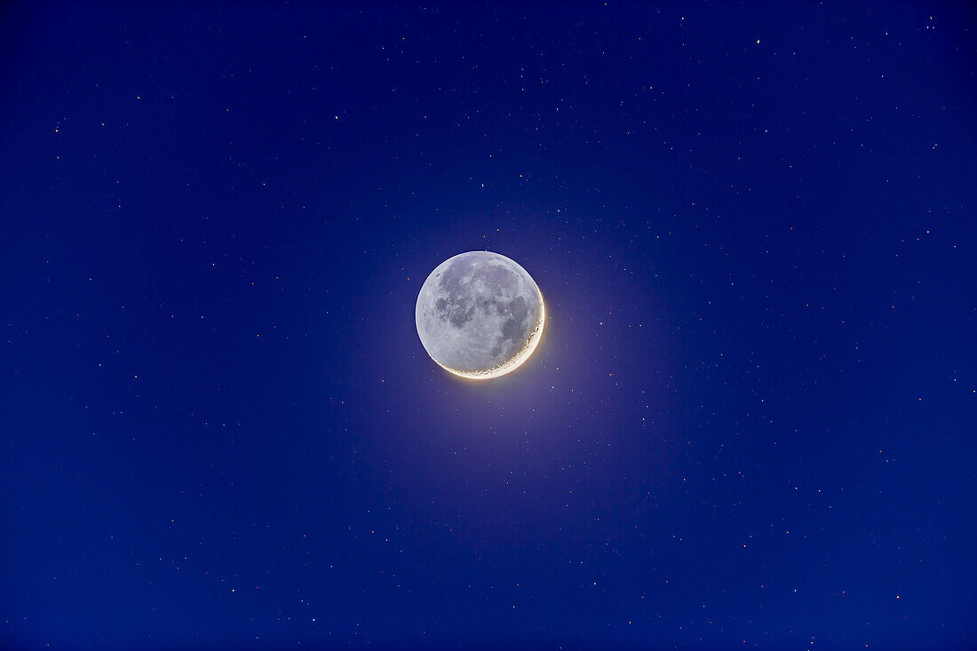 Die 2 Tage alte Mondsichel mit Erdschein, eingebettet in die Sterne und das tiefe Blau der Dämmerung, am 24. November 2014. Aufgenommen in der Nähe von Silver City, New Mexico mit dem TMB 92mm Refraktor bei f/5.5 und Canon 6D bei ISO 100. Die Sterne sind leicht nachgezogen, da das Teleskop dem Mond mit der Nachführrate des Mondes folgte.