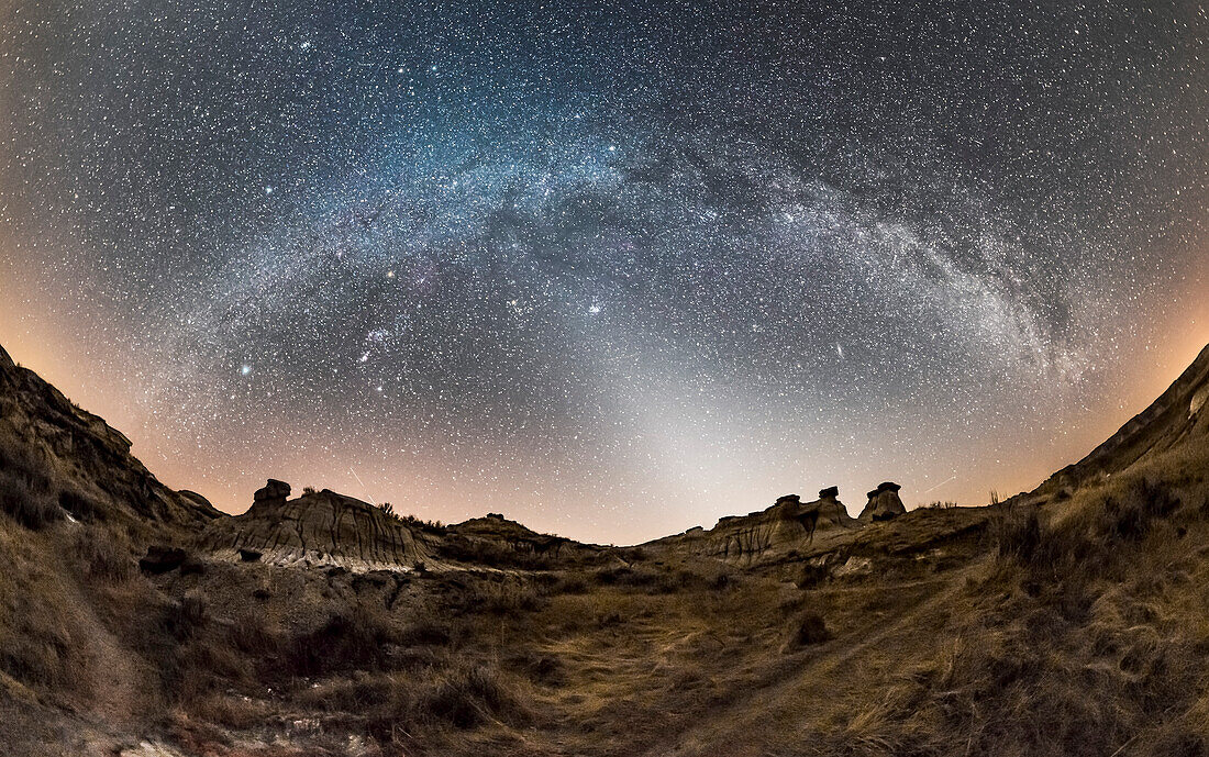 A 200+ degree panorama of the arch of the winter Milky Way, from south (left) to northwest (ar right) with the Zodiacal Light to the west at centre. This was from Dinosaur Provincial Park in southern Alberta on February 28, 2017. A spell of warm weather left very little snow, so the landscape does not look like winter here. But the sky is!