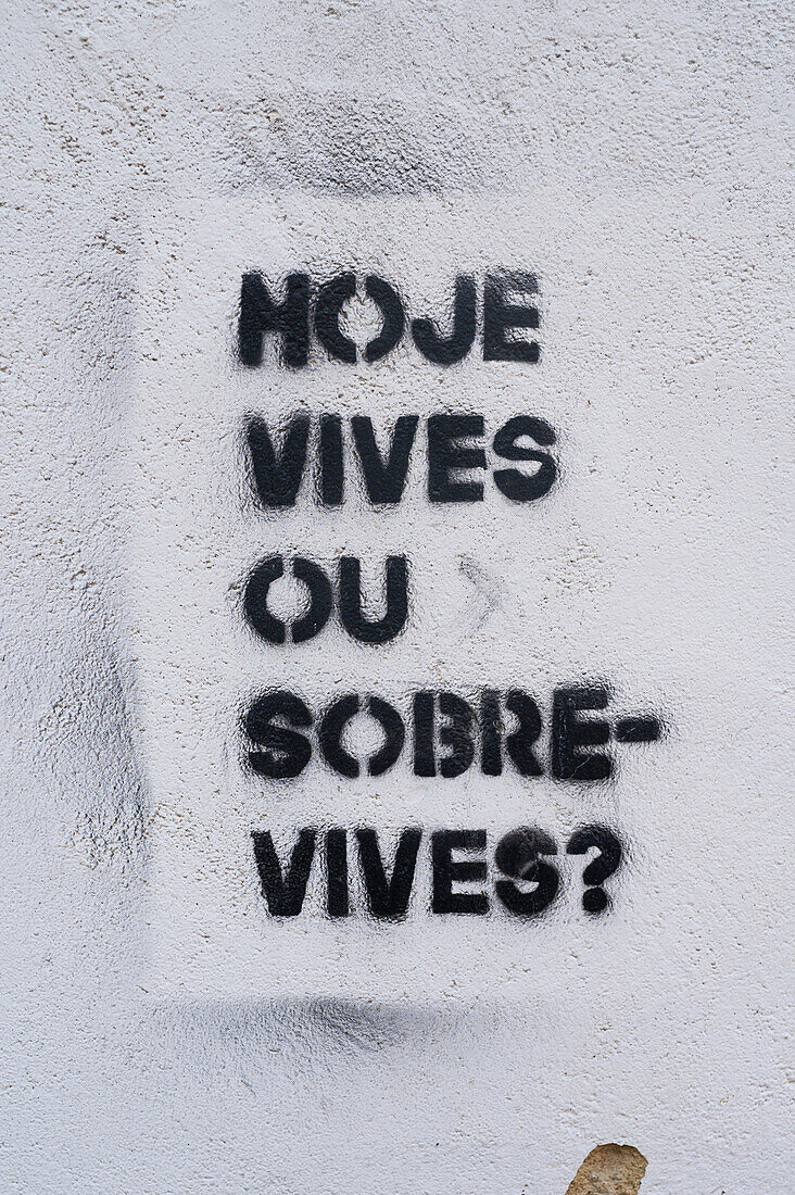 Die Straßenmalerei lautet Hoje vives ou sobrevives? / Lebst du heute oder überlebst du?, Sintra, Portugal