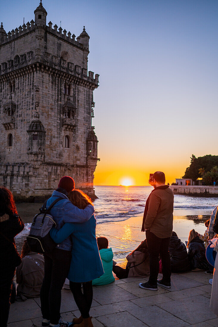 Menschen genießen einen schönen Sonnenuntergang vom Turm von Belem oder dem Turm von St. Vincent am Ufer des Flusses Tejo, Lissabon, Portugal
