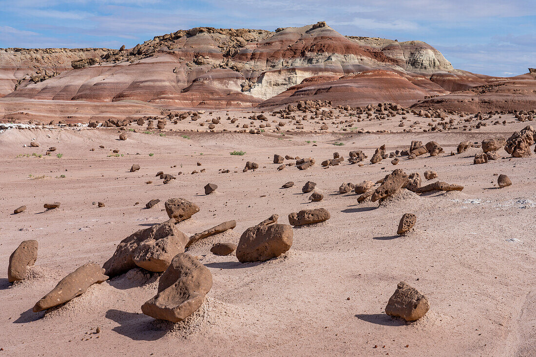 A sandstone boulder field and colorful bentonite clay hills of the Morrison Formation in the Caineville Desert near Hanksville, Utah.