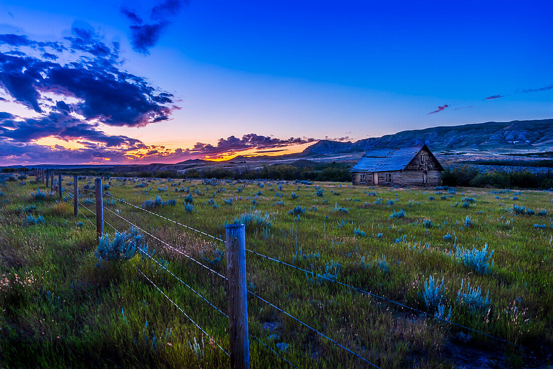 Sunset over an old cabin in the Frenchman River valley near Eastend, Saskatchewan, amid the sagebrush and badlands of the valley.