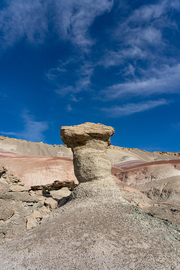 A sandstone caprock on a clay hoodoo in the bentonite hills of the Caineville Desert near Hanksville, Utah.