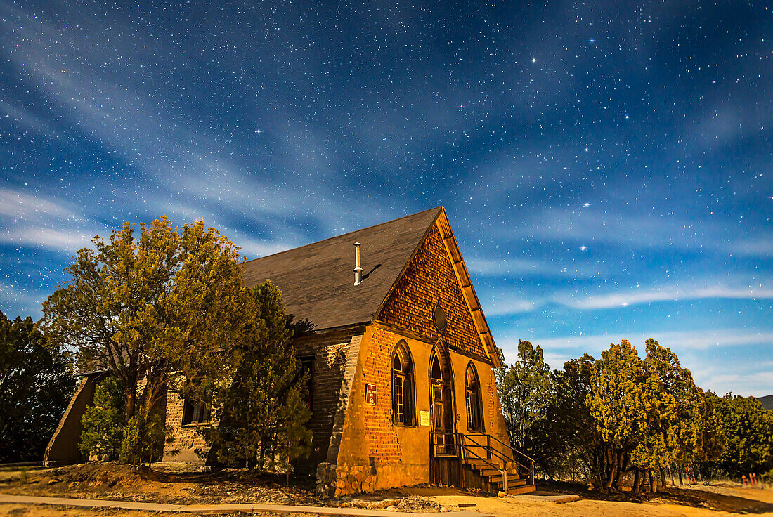 Dies ist eine mondbeschienene Nachtlandschaft der historischen Hearst Church in Pinos Altos, New Mexico, auf 7000 Fuß Höhe (daher der Name High Pines) und auf der Kontinentalscheide. Am Himmel oben ist der Große Wagen rechts und der Polarstern links über der Kirche zu sehen.