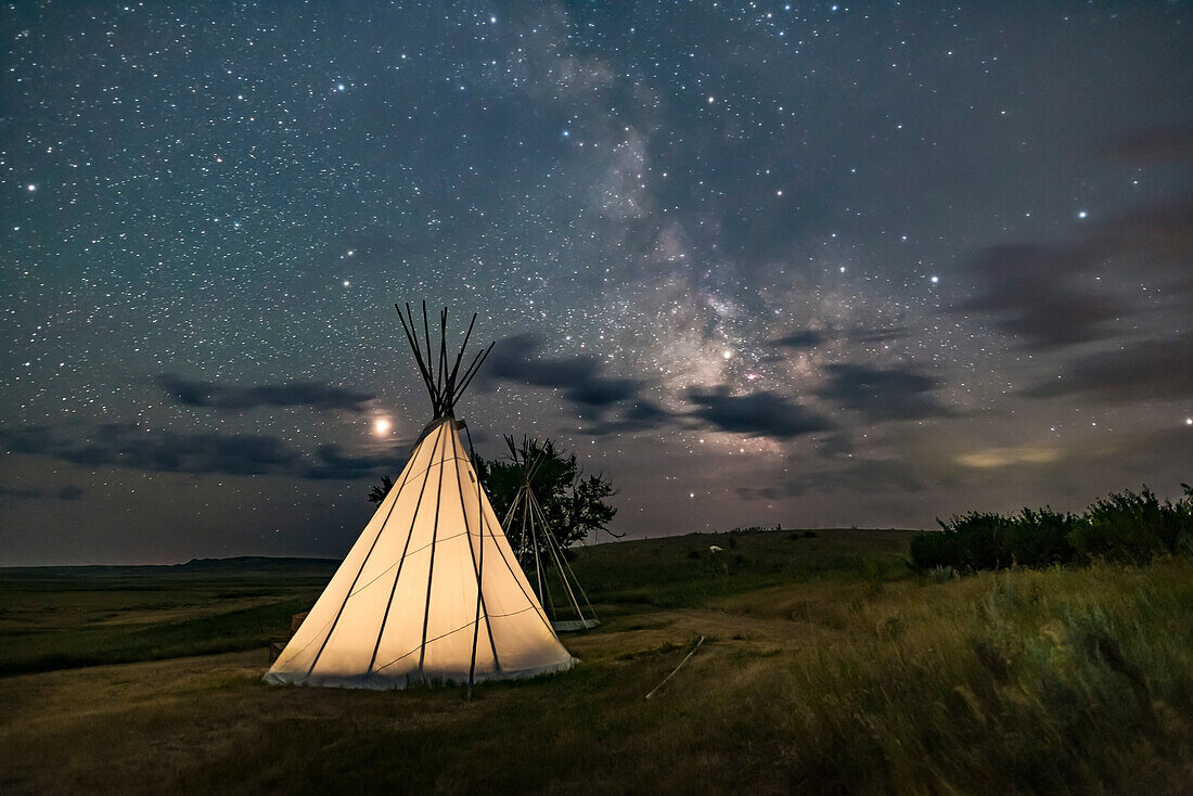 Mars (links) und die Milchstraße (rechts) über einem einzelnen Tipi (mit einem weiteren im Bau befindlichen auf der Rückseite) an der Two Trees Site im Grasslands National Park, Saskatchewan, 6. August 2018. Für die Beleuchtung habe ich ein schwaches warmes LED-Licht im Inneren des Tipis angebracht.