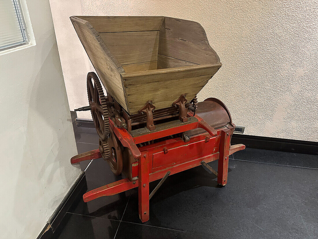 An antique portable grape crushing machine on display in a hotel in Mendoza, Argentina.