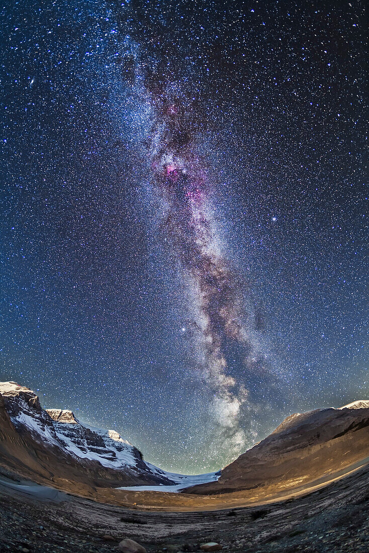 The Milky Way over Athabasca Glacier and the Columbia Icefields in Jasper National Park, Sept 14, 2014 on a very clear night before moonrise. The centre of the Galaxy area in Sagittarius is setting in the southwest behind the Icefields. The foreground light on the moraines is wash from lights on the Glacier View Inn and Icefields Centre. Other ground illumination on the peaks is from starlight though the tops of the peaks are just being lit by light from the rising waning Moon which is also beginning to light the sky a deep blue. Mt. Andromeda is at left. The Summer Triangle stars are at centr