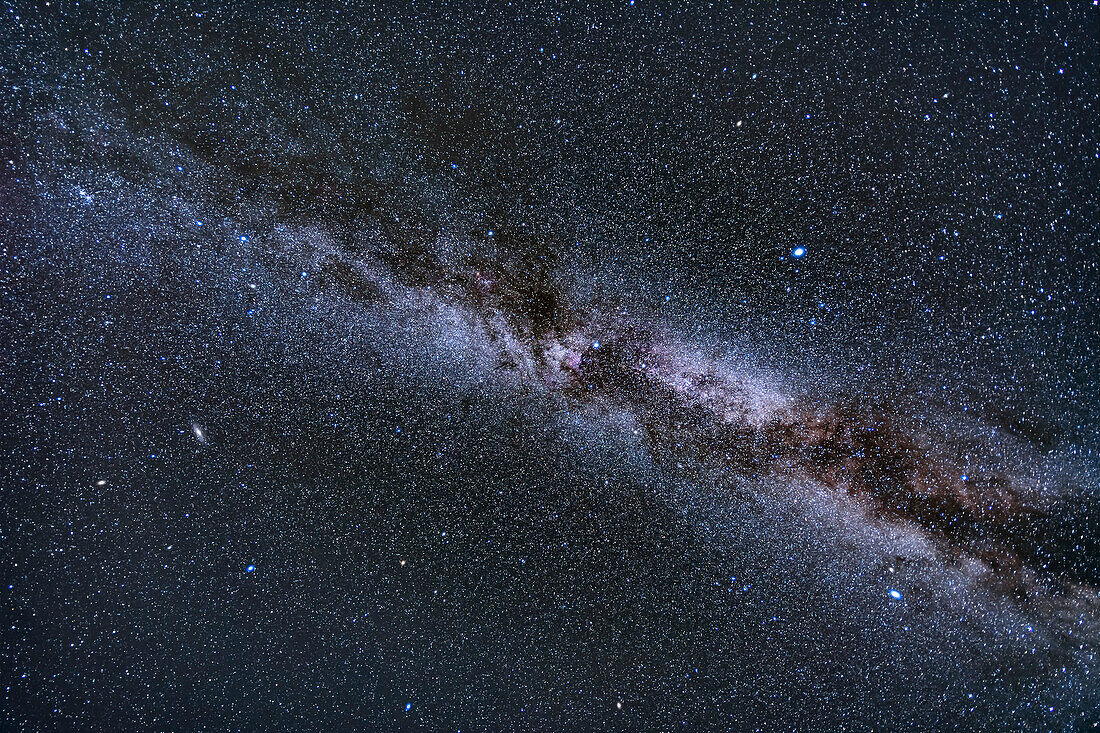 Ein Weitwinkel-Blick auf die herbstliche Milchstraße der nördlichen Hemisphäre, von Aquila unten rechts im Süden bis Cassiopeia und Perseus oben links im Nordosten. Cygnus ist an einem späten Oktoberabend in der Mitte zu sehen. Die Sterne des Sommerdreiecks befinden sich in der Mitte und rechts, die Galaxien Andromeda und Triangulum unten links. Der Dunkelnebel Le Gentil 3, auch Trichternebel genannt, befindet sich in der Mitte.