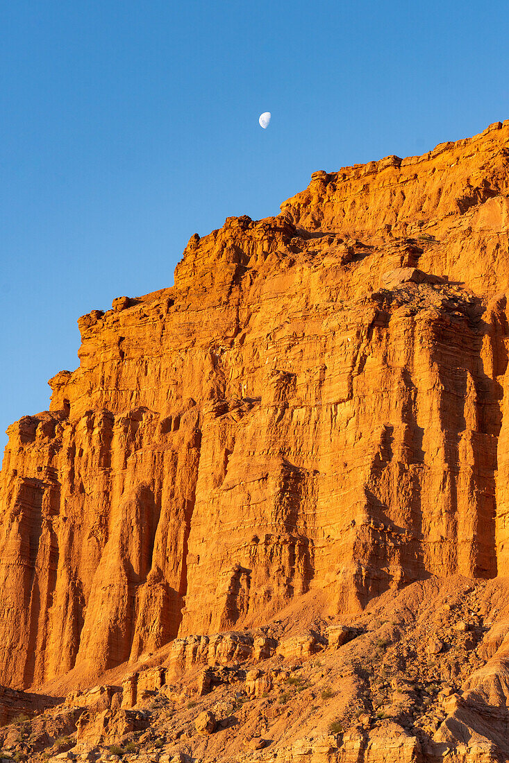 Der Mond über roten Sandsteinfelsen bei Sonnenuntergang im Ischigualasto Provincial Park, Provinz San Juan, Argentinien.