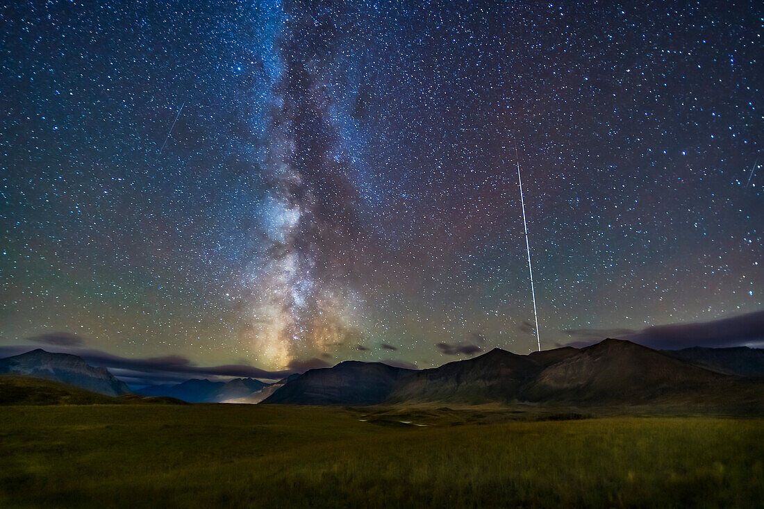 Die nördliche Sommermilchstraße, die über den Bergen des Waterton Lakes National Park, Alberta, Kanada, untergeht, mit der Raumstation rechts, die dann in den Sonnenuntergang übergeht, in einer Spur aus der Serie von Langzeitbelichtungen. Dieses Bild wurde am 21. September 2019 vom Aussichtspunkt Bison Compound aus in Richtung Süden und Südwesten aufgenommen und ist Teil eines Zeitraffers.