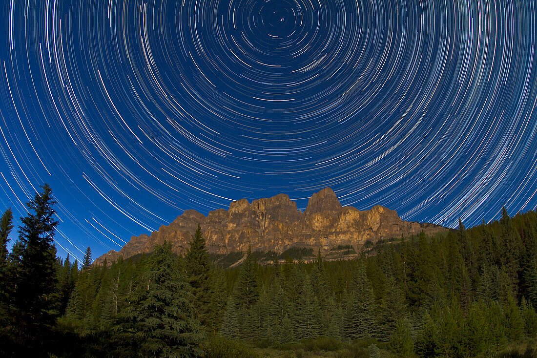 Zirkumpolarer Sternenschweif über dem Castle Mountain in Banff, Alberta. Aufgenommen am 23. Juli 2010 vom Aussichtspunkt Castle Cliffs am Bow Valley Parkway. Ein Stapel von 160 25-Sekunden-Belichtungen mit dem Canon 15mm Objektiv bei f/4 und der Canon 7D Kamera bei ISO 640. Aufgenommen über 2 Stunden. Vollmondlicht sorgte für die Beleuchtung.