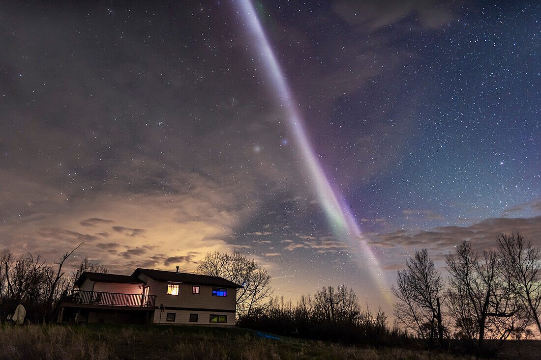 The unusual STEVE auroral arc over my house in southern Alberta, on May 6, 2018, on a partly cloudy night. A dim and inactive main aurora was to the north, but the Steve arc crossed the sky from east to west.