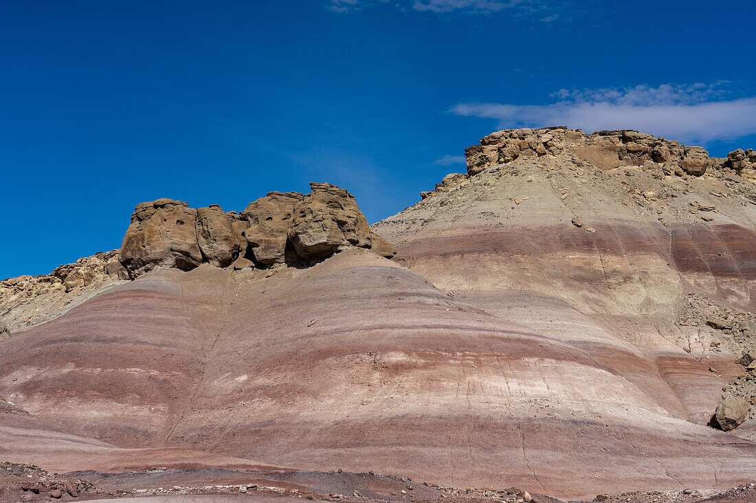 Sandsteinblöcke auf den bunten Bentonit-Ton-Hügeln der Morrison-Formation in der Caineville-Wüste bei Hanksville, Utah.