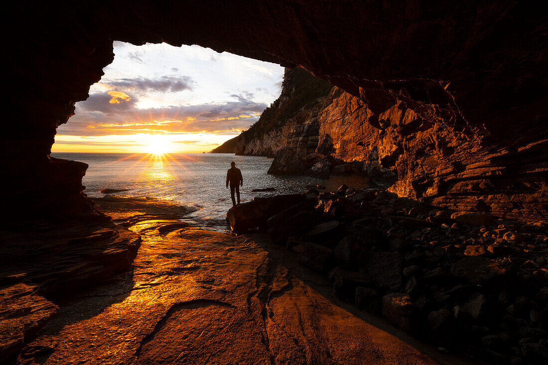 Ein Junge bewundert einen schönen Frühlings-Sonnenuntergang von der Byron-Höhle aus, Portovenere, Provinz La Spezia, Bezirk Ligurien, Italien, Europa