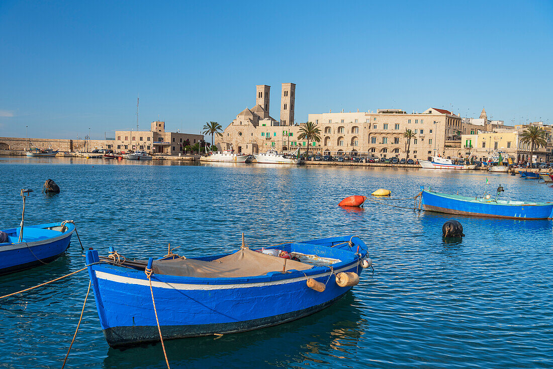 Small blue boats moored in the water of the harbour of the old medieval town of Barletta, Adriatic Sea, Mediterranean Sea, Apulia, Italy, Europe