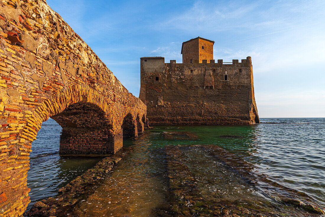 Blick von unten auf die Bögen der Brücke, die die Burg Torre Astura mit dem Festland verbindet, bei Sonnenuntergang, Tyrrhenisches Meer, Provinz Rom, Region Latium (Lazio), Italien, Europa