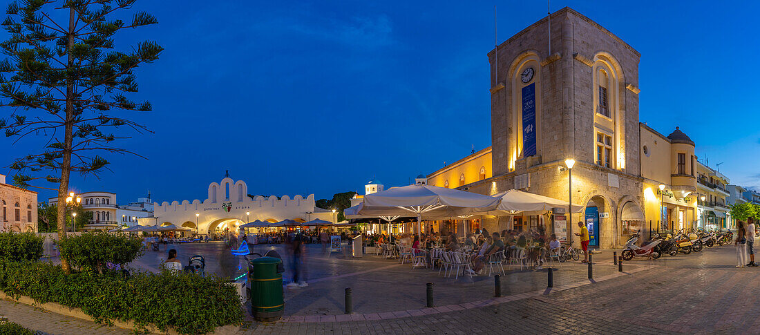 View of cafe and restaurant in Eleftherias Central Square in Kos Town at dusk, Kos, Dodecanese, Greek Islands, Greece, Europe