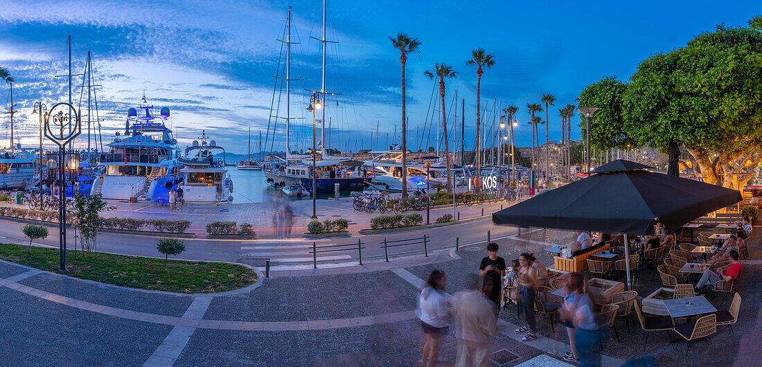 Blick auf Cafés und Boote im Hafen von Kos in der Abenddämmerung, Kos-Stadt, Kos, Dodekanes, Griechische Inseln, Griechenland, Europa
