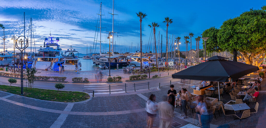 View of cafes and boats in Kos Harbour at dusk, Kos Town, Kos, Dodecanese, Greek Islands, Greece, Europe