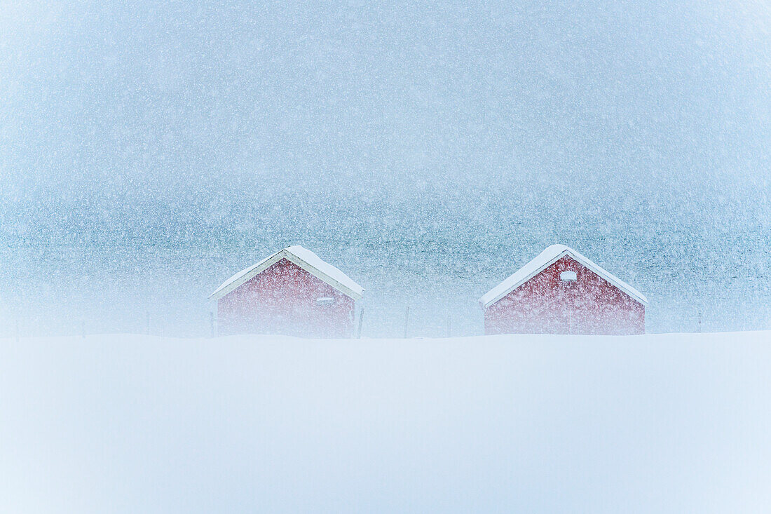 Rote Hütten im Nebel bei starkem Schneefall, Provinz Troms, Norwegen, Skandinavien, Europa