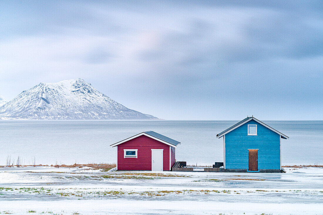 Traditionelle Rorbu-Hütten mit Blick auf das zugefrorene Meer, Provinz Troms, Norwegen, Skandinavien, Europa