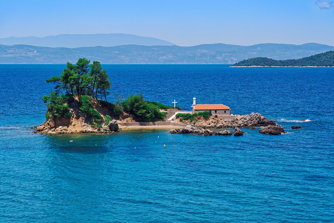 Kleine christliche Kirche, steinerne Kapelle mit Kreuz auf einem kleinen Inselstreifen im ruhigen Meer, Griechische Inseln, Griechenland, Europa
