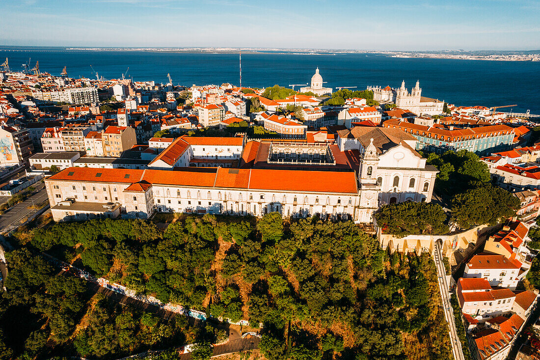 Drohnenaufnahme des Miradouro da Graca mit dem Nationalen Pantheon und einem großen Kreuzfahrtschiff, das im Hafen des Tejo anlegt, Lissabon, Portugal, Europa