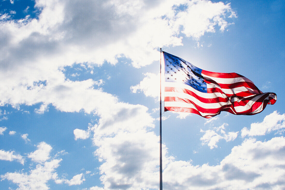 Amerikanische Flagge weht im Wind gegen den Himmel an einem sonnigen Tag