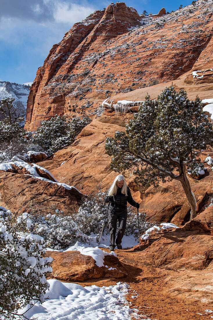 USA, Utah, Springdale, Zion National Park, Ältere Frau beim Wandern in den Bergen im Winter