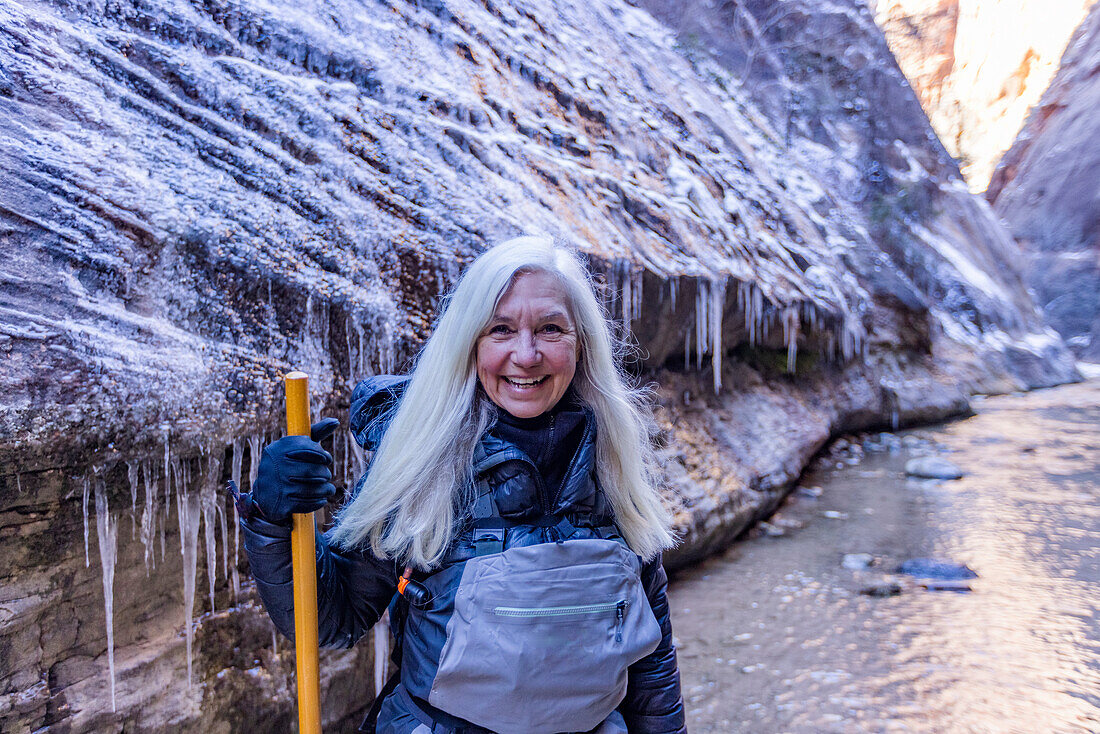 USA, Utah, Springdale, Zion National Park, Ältere Frau überquert Fluss beim Wandern in den Bergen