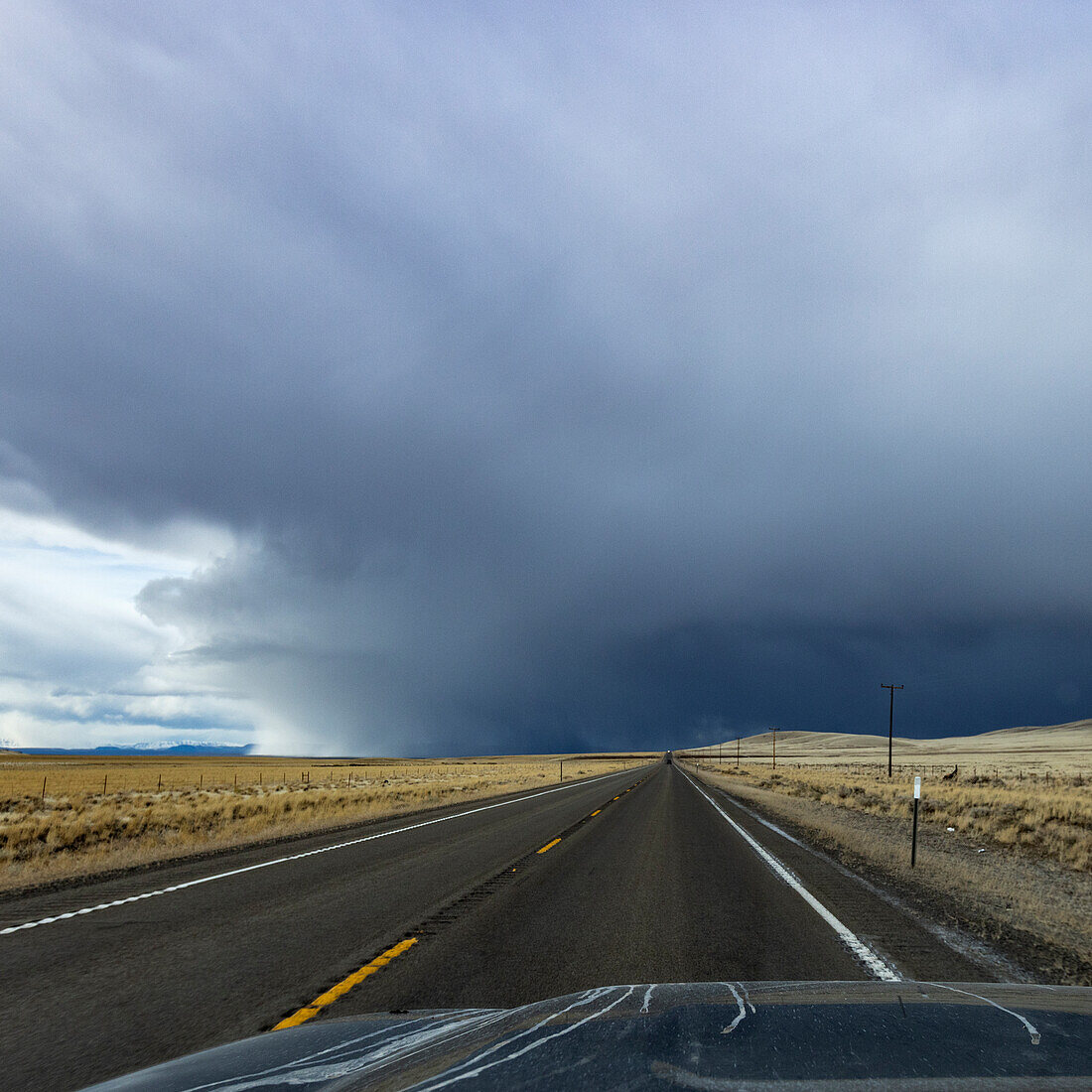 USA, Nevada, McDermitt, Highway leading towards storm clouds on horizon