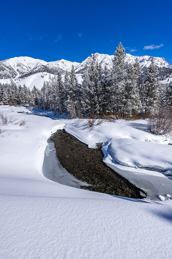 USA, Idaho, Sun Valley, River flowing in mountains in winter