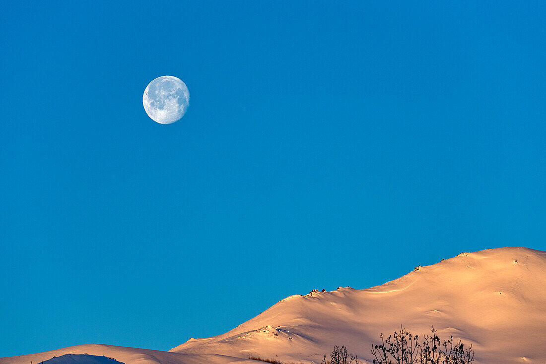 USA, Idaho, Sun Valley, Vollmond über schneebedeckten Hügeln