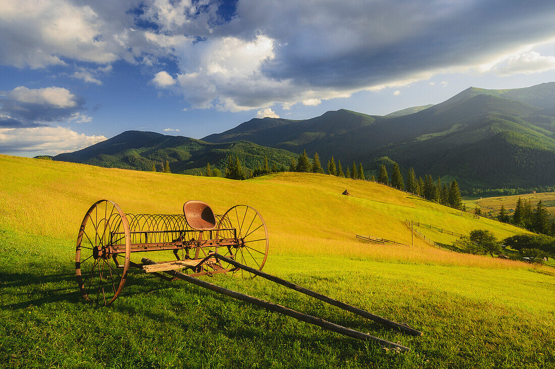Ukraine, Ivano Frankivsk region, Verkhovyna district, Dzembronya village, Old farm machine in rural landscape in Carpathian Mountains