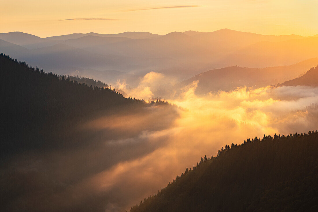 Ukraine, Ivano Frankivsk region, Verkhovyna district, Dzembronya village, Foggy Carpathian Mountains landscape at sunset